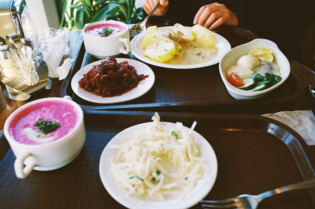 Two trays of food with pink creamy borsch